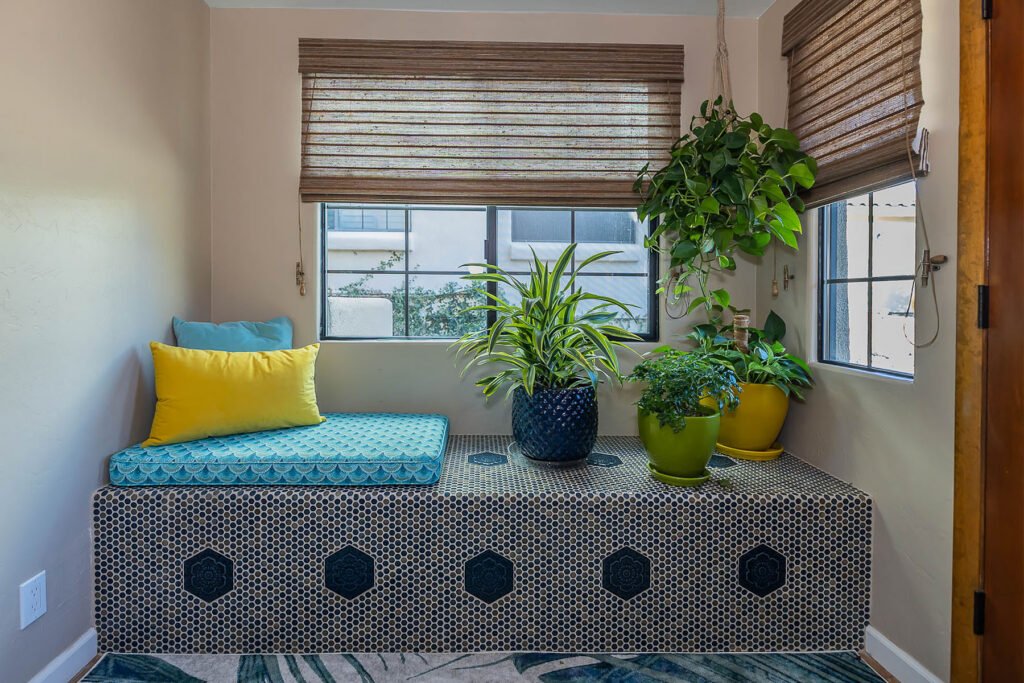 Built in tiled entry bench with plants and custom cushions.
