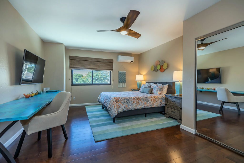 Guest Bedroom Desk and floral bedding on striped rug.