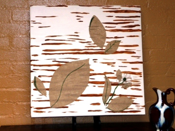 Reinvent Your Art For A Fresh New Look earth tone wall art. fabric background with brown paint wood grain look and burlap cut into leaves and flowers with twine.